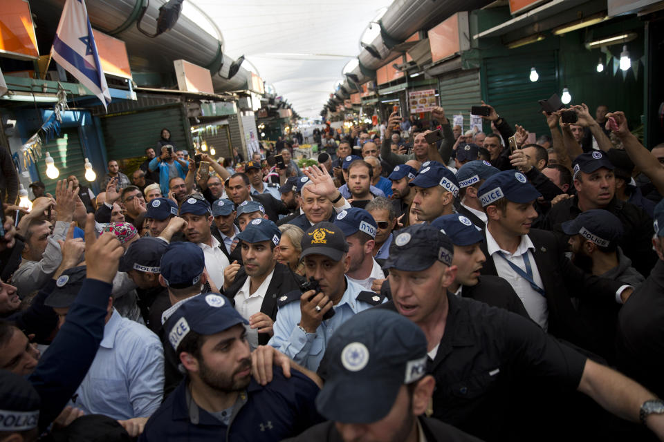 File - In this Tuesday, April 2, 2019 file photo, Israeli Prime Minister and head of the Likud party Benjamin Netanyahu, center, is escorted by security guards during a visit to the Ha'tikva market in Tel Aviv. Israel's election campaign has been a three-month roller coaster of mudslinging, scandals and more scandals. But when voters head to the polls on Tuesday, one name will be predominantly on their minds: Benjamin Netanyahu. (AP Photo/Oded Balilty, File)