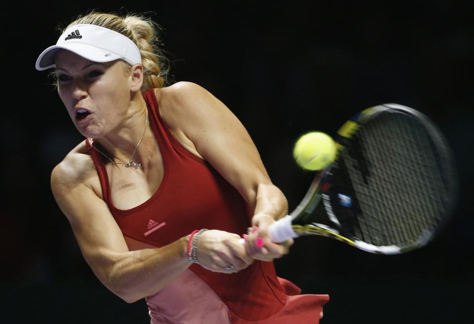 Caroline Wozniacki of Denmark hits a return to Serena Williams of the U.S. during their WTA Finals singles semi-finals tennis match at the Singapore Indoor Stadium