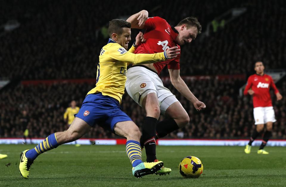 Arsenal's Jack Wilshere challenges Manchester United's Phil Jones (R) during their English Premier League soccer match at Old Trafford in Manchester, northern England, November 10, 2013.