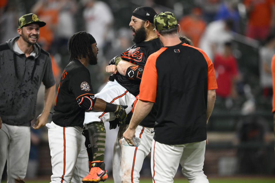 Baltimore Orioles' Rougned Odor, center, celebrates with teammates Cedric Mullins, second from left, Trey Mancini, left, and others after he hit a two-run walkoff home run during the 13th inning of a baseball game against the Tampa Bay Rays, Friday, May 20, 2022, in Baltimore. (AP Photo/Nick Wass)