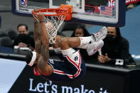 Washington Wizards guard Bradley Beal hangs from the rim after dunking against the Oklahoma City Thunder in the second half of an NBA basketball game, Monday, April 19, 2021, in Washington. (AP Photo/Patrick Semansky)