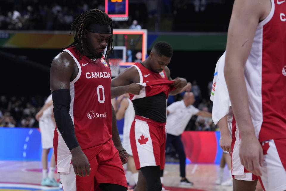 Canada guard Luguentz Dort, left, and teammate Melvin Ejim walks off after their loss to Serbia in a Basketball World Cup semi final game in Manila, Philippines, Friday, Sept. 8, 2023. (AP Photo/Michael Conroy)