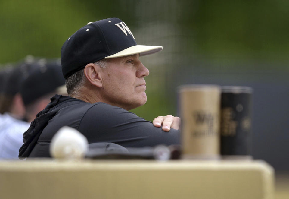 Wake Forest head coach Tom Walter watches from the dugout in the early innings of the Deacons' 11-1 win over Coastal Carolina in an NCAA college baseball game, Tuesday, April 25, 2023, at Couch Field in Winston-Salem, N.C. Baseball has often played a secondary role during his 27-year career even though he has won more than 800 games and taken three different schools to the national tournament. (Walt Unks/The Winston-Salem Journal via AP)