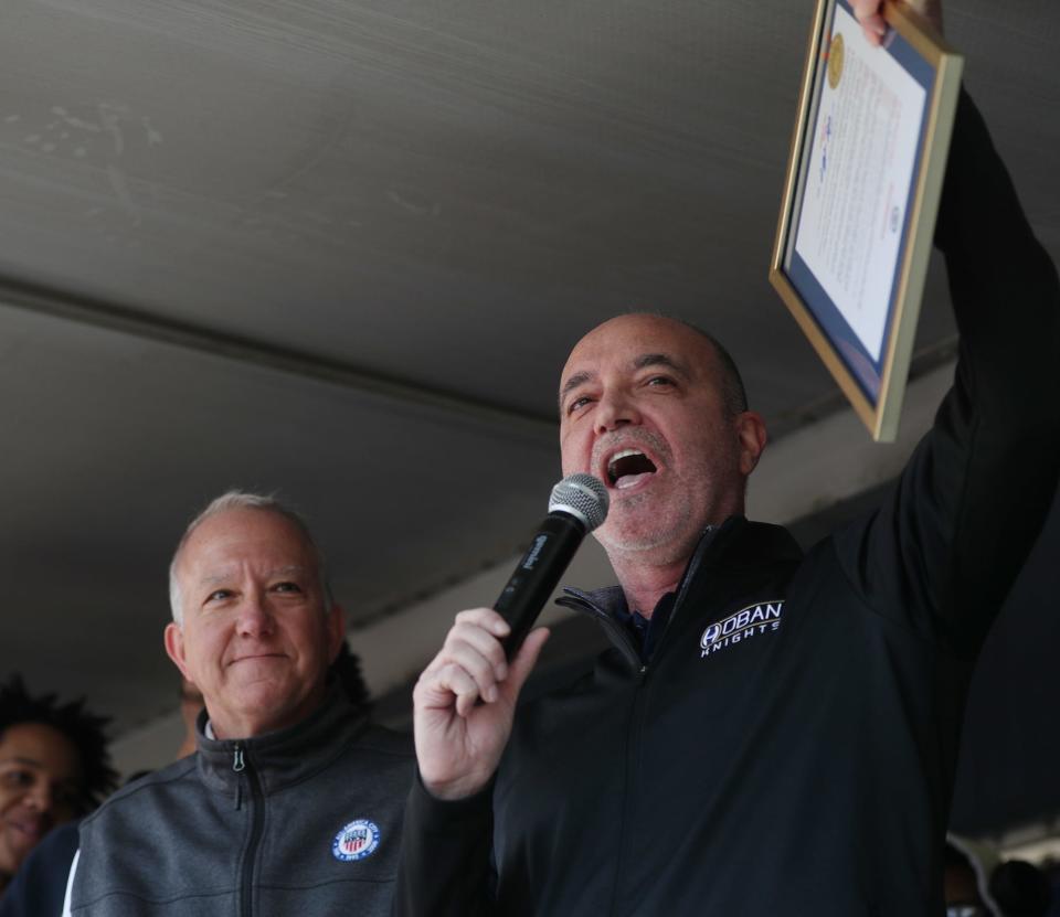 Akron mayor Dan Horrigan looks on as Archbishop Hoban's head coach T.K. Griffith leads a cheer during the Akron Parade of Champions on Main Street to celebrate State basketball champs Buchtel High and Archbishop Hoban High in Akron on Sunday.