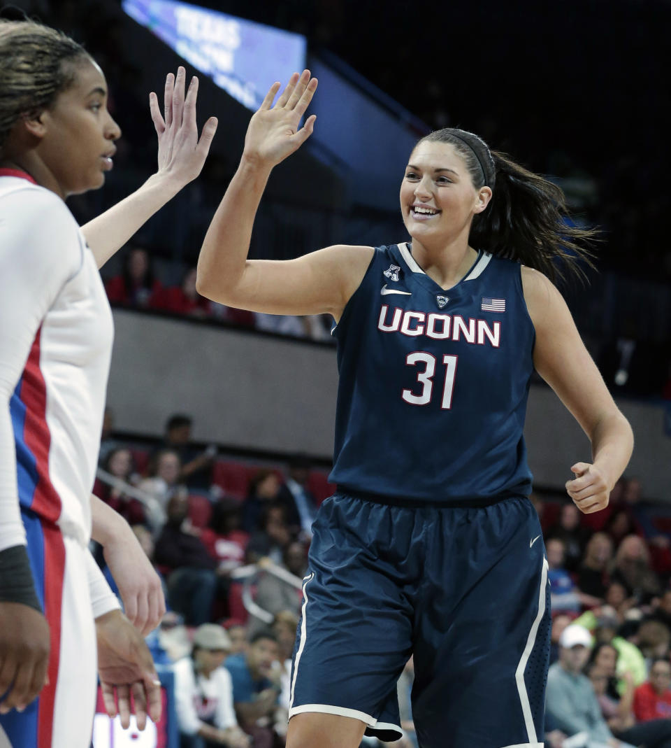 Connecticut center Stefanie Dolson (31) celebrates with a teammate in front of SMU forward Akil Simpson (5) during the second half of an NCAA college basketball game Tuesday, Feb. 25, 2014, in Dallas. Connecticut won 81-48. (AP Photo/LM Otero)