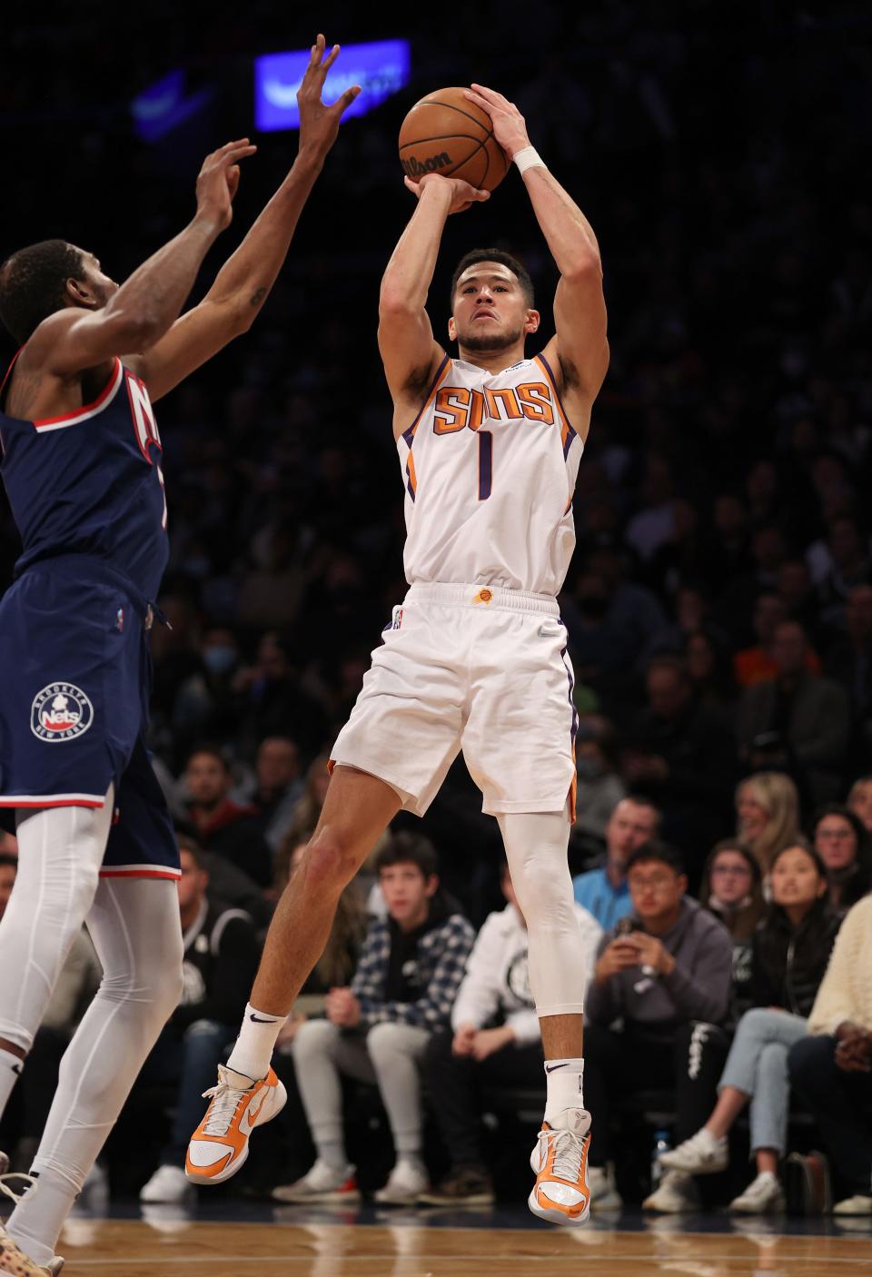 NEW YORK, NEW YORK - NOVEMBER 27:  Devin Booker #1 of the Phoenix Suns takes a shot as Kevin Durant #7 of the Brooklyn Nets defends in the first half Barclays Center on November 27, 2021 in New York City. NOTE TO USER: User expressly acknowledges and agrees that, by downloading and or using this photograph, User is consenting to the terms and conditions of the Getty Images License Agreement. (Photo by Elsa/Getty Images)