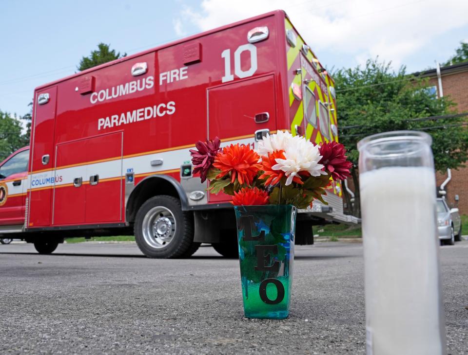 Flowers and candles sit in a parking lot at Southpark Apartments on June 21 on the South Side of Columbus after a weekend shooting claimed the lives of two people, Zeinab Bilal, 21, who was shot by her brother, Abdihakim Abdulai Bilal, 16, who then shot himself.
