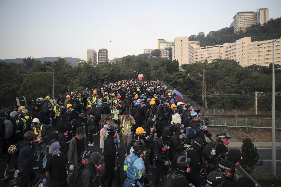 Pro-democracy protesters gather on a bridge outside the the Chinese University of Hong Kong, in Hong Kong, Wednesday, Nov. 13, 2019. Protesters in Hong Kong battled police on multiple fronts on Tuesday, from major disruptions during the morning rush hour to a late-night standoff at a prominent university, as the 5-month-old anti-government movement takes an increasingly violent turn. (AP Photo/Kin Cheung)