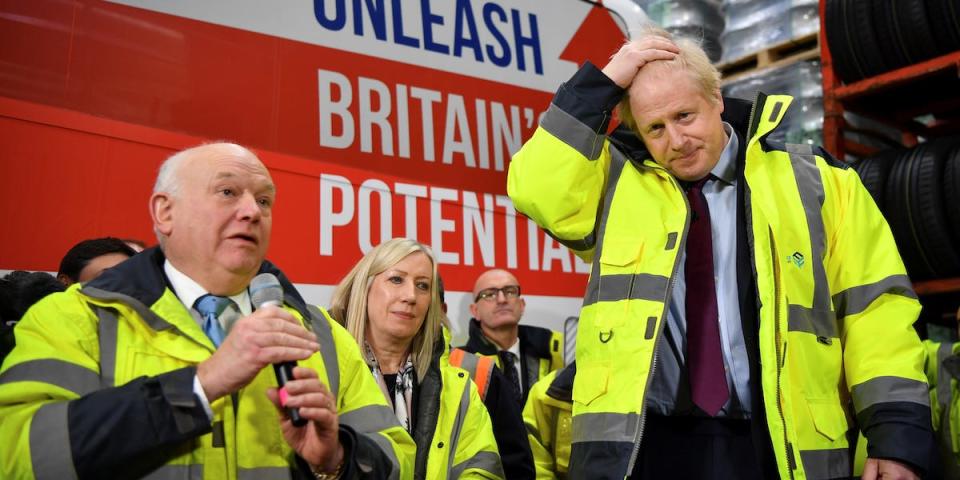 Britain's Prime Minister Boris Johnson campaigns in Washington Britain's Prime Minister and Conservative leader Boris Johnson stands next to CEO Alan Ferguson as he talks at a Q&A session during a general election campaign visit to Fergusons Transport in the town of Washington, west of Sunderland, Britain, December 9, 2019. Ben Stansall/Pool via REUTERS