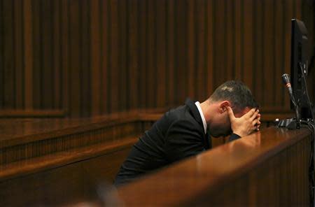 Olympic and Paralympic track star Oscar Pistorius reacts as he sits in the dock during his trial for the murder of his girlfriend Reeva Steenkamp at the North Gauteng High Court in Pretoria, March 17, 2014. REUTERS/Siphiwe Sibeko