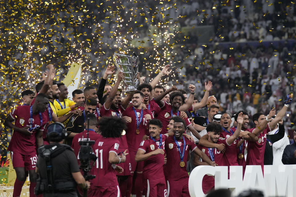 Qatar players celebrate with the trophy after winning the Asian Cup final soccer match between Qatar and Jordan at the Lusail Stadium in Lusail, Qatar, Saturday, Feb. 10, 2024. Qatar won 3-1. (AP Photo/Aijaz Rahi)