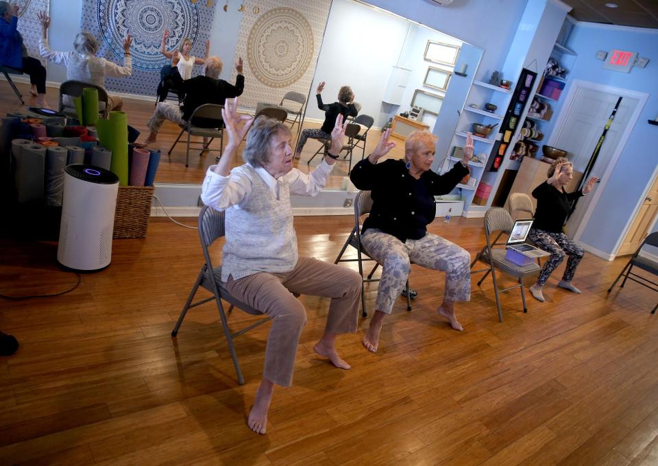 Women participate in Bella Buddha Yoga owner Brenda Yarnold's chair yoga class at the Belmar studio Monday, April 10, 2023.