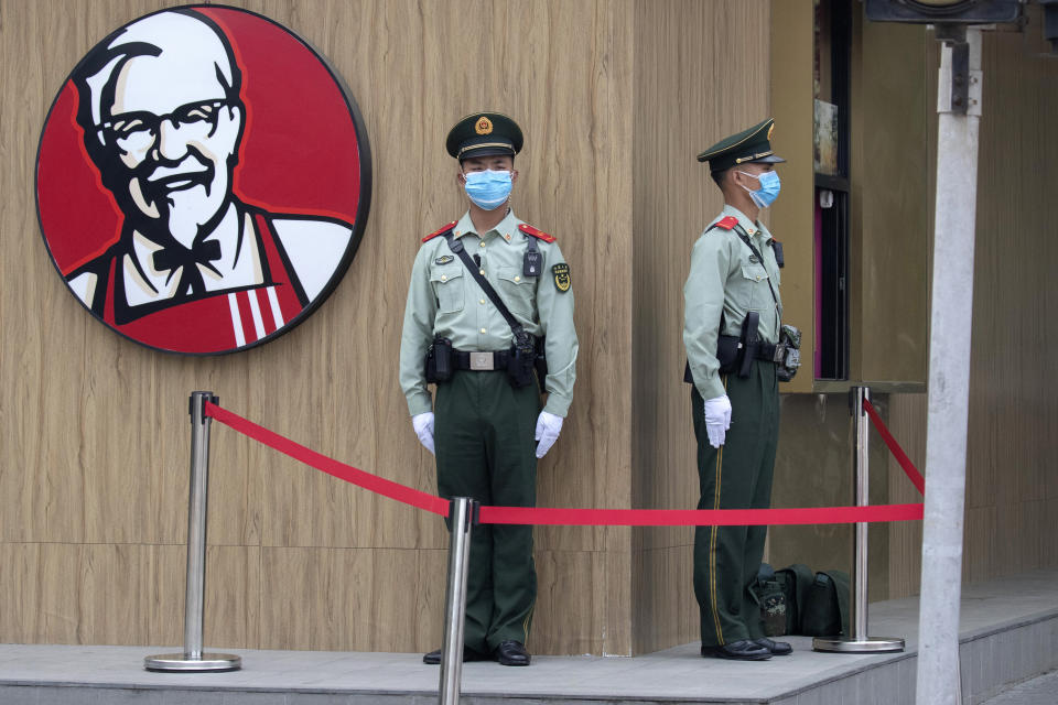 Chinese paramilitary policemen wearing masks to curb the spread of the new coronavirus stand guard near a logo for KFC before the opening session of the Chinese People's Political Consultative Conference (CPPCC) is to be held at the Great Hall of the People in Beijing, Thursday, May 21, 2020. (AP Photo/Ng Han Guan)