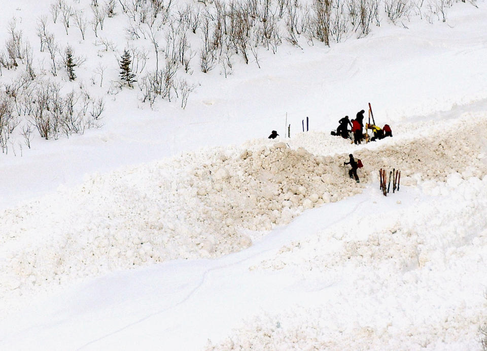 FILE - Mountain Rescue personnel work to free the body of an avalanche victim at the base of the Five Fingers Bowl near Aspen, Colo., in this March 6, 2005, file photo. This has been an highly dangerous avalanche season, with 30 confirmed fatalities. It's involved different recreational activities — snowboarding, skiing, snowmobiling, hiking — and includes various ages and experience levels. (AP Photo/The Aspen Times, Paul Conrad, File)