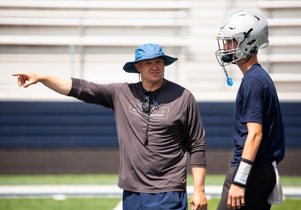 Granville head coach Wes Schroeder talks with quarterback Tyler Ernsberger during a 7-on-7 passing scrimmage against Newark Catholic last month at Walter J. Hodges Stadium.