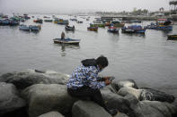 A fishermen rests near the dock in Ancon, Peru, Thursday, Jan. 20, 2022. The oil spill on the Peruvian coast caused by the waves from an eruption of an undersea volcano in the South Pacific nation of Tonga has expanded along the coastline, reaching Ancon, a fishing and touristic port. (AP Photo/Martin Mejia)