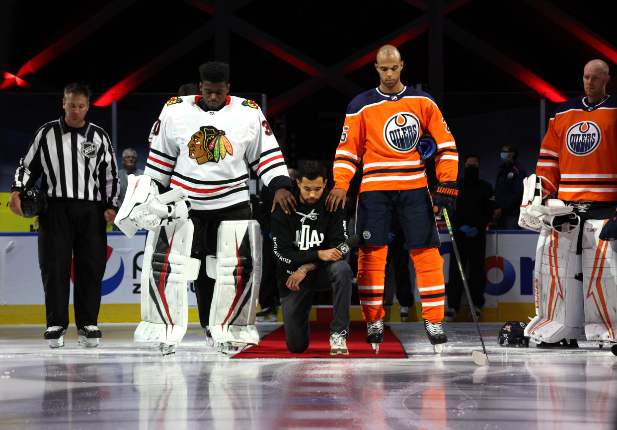 EDMONTON, ALBERTA - AUGUST 01: Malcolm Subban #30 of the Chicago Blackhawks and Darnell Nurse #25 of the Edmonton Oilers place their hands on Mathew Dumba of the Minnesota Wild during the national anthem of the United States before Game One of the Western Conference Qualification Round between the Edmonton Oilers and the Chicago Blackhawks at Rogers Place on August 01, 2020 in Edmonton, Alberta.  (Photo by Dave Sandford/NHLI via Getty Images)