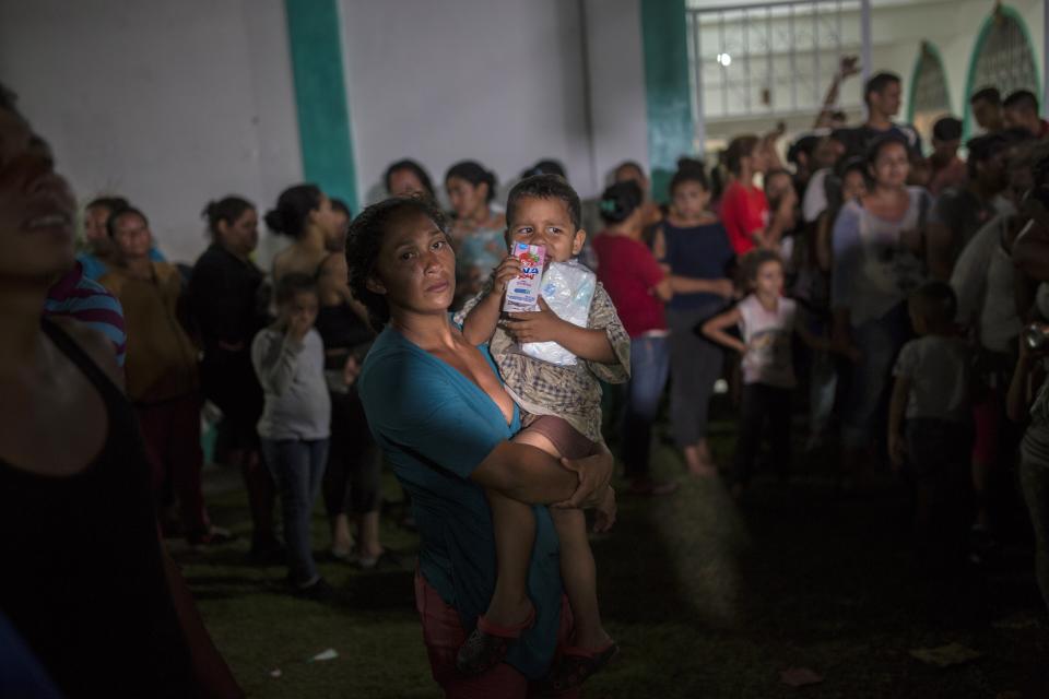 Honduran migrants wait to receive dinner at a makeshift shelter in Ciudad Hidalgo, Mexico, Monday, on Oct. 29. (AP Photo/Rodrigo Abd)