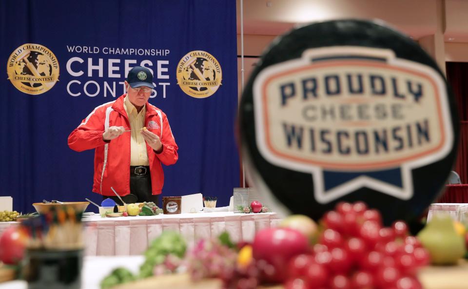 Ernest Gebhardt Jr. of Monroe, with the National Historic Cheesemaking Center Museum, samples a selection of spreadable cheeses during the 2024 World Championship Cheese Contest on March 5, 2024, at Monona Terrace Community and Convention Center in Madison, Wis.