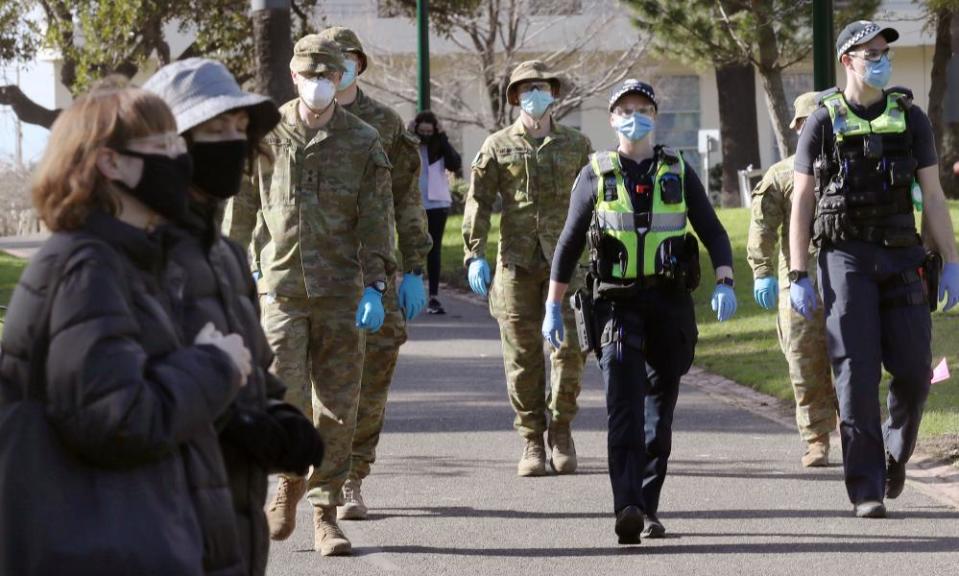 Australian Defence Force personnel and Victoria police officers patrol Fitzroy Gardens in Melbourne