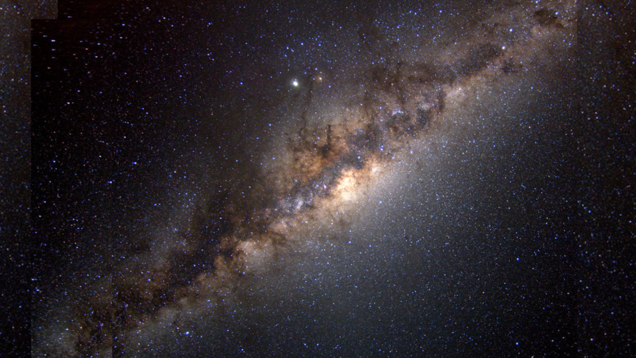  Lots of stars are seen in the image. A central, straight structure goes diagonally from the bottom left to the top right; it has strings of gas, bright sections and other features. It represents the Milky Way's heart. 