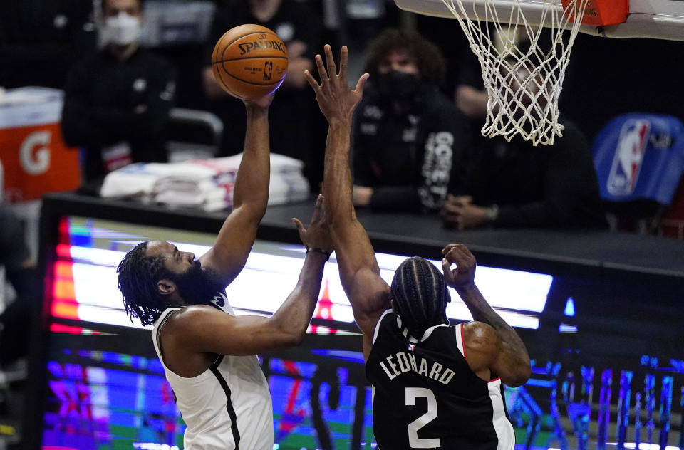 Brooklyn Nets guard James Harden, left, shoots as Los Angeles Clippers forward Kawhi Leonard defends during the first half of an NBA basketball game Sunday, Feb. 21, 2021, in Los Angeles. (AP Photo/Mark J. Terrill)
