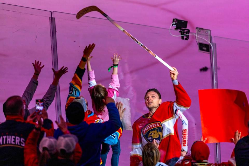 Florida Panthers center Sam Reinhart (13) gives a young fan a hockey stick after his team defeated the New York Rangers during an NHL game at Amerant Bank Arena in Sunrise, Florida, on Friday, December 29, 2023.