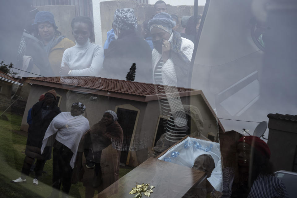 Mourners look at the body of 5-year-old Wandi Zitho at his funeral in Orange Farm, South Africa, on April 28, 2020. The boy was murdered in a suspected witchcraft ritual and his body was found in his neighbor's tavern. (AP Photo/Bram Janssen)