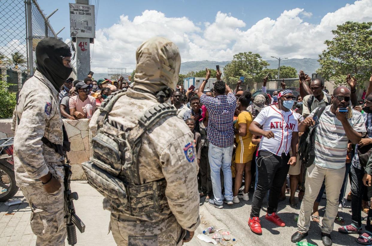 <span class="caption">Haitians seeking asylum gather July 10, 2021, at the U.S. Embassy in Haiti after the president's assassination plunged the country further into chaos,</span> <span class="attribution"><a class="link " href="https://www.gettyimages.com/detail/news-photo/police-look-on-as-haitian-citizens-gather-in-front-of-the-news-photo/1233910041" rel="nofollow noopener" target="_blank" data-ylk="slk:VALERIE BAERISWYL/AFP via Getty Images;elm:context_link;itc:0;sec:content-canvas">VALERIE BAERISWYL/AFP via Getty Images</a></span>