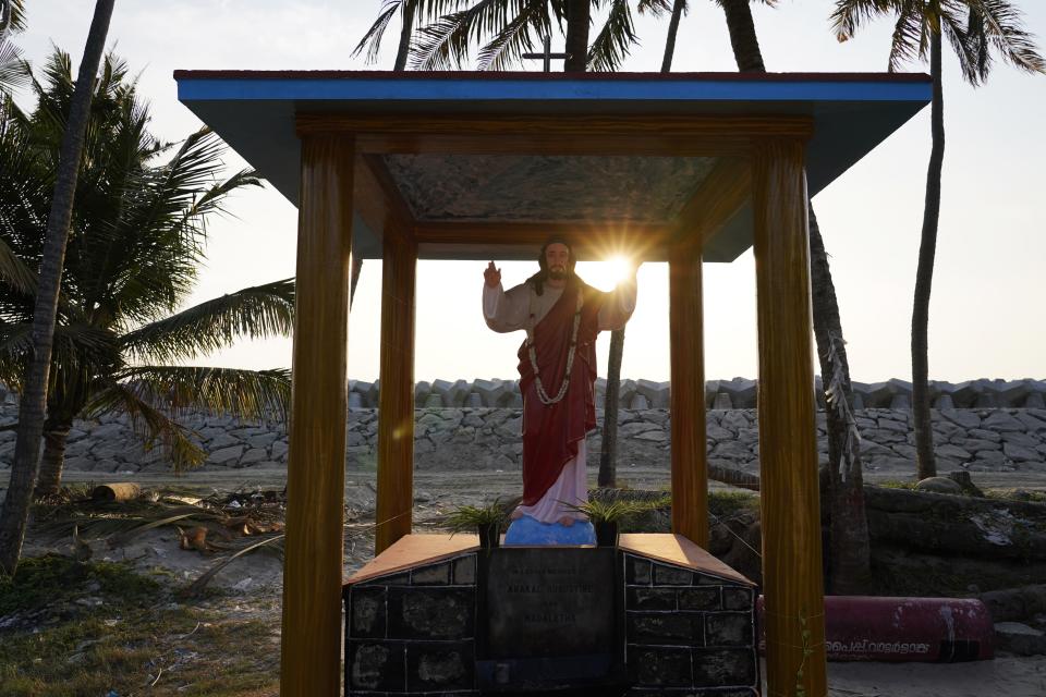 The sun sets behind a statue of Jesus Christ and a newly built sea wall in Kochi, Kerala state, India, March 4, 2023. Tens of millions of people in India live along coastlines and thus are exposed to major weather events. One common adaptation technique, in India and other countries hit hard by rising seas and oceanic storms, is to build sea walls. (AP Photo)