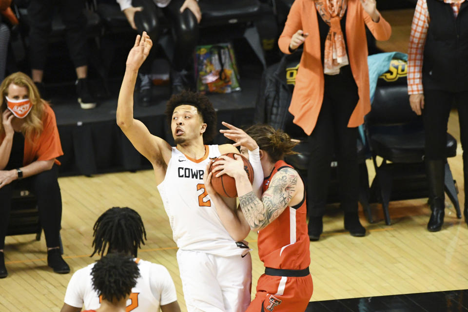 Oklahoma State guard Cade Cunningham (2) attempts to shoot in the final seconds of regulation play while being tied up by Texas Tech guard Avery Benson (21) during an NCAA college basketball game Monday, Feb. 22, 2021, in Stillwater, Okla. (AP Photo/Brody Schmidt)