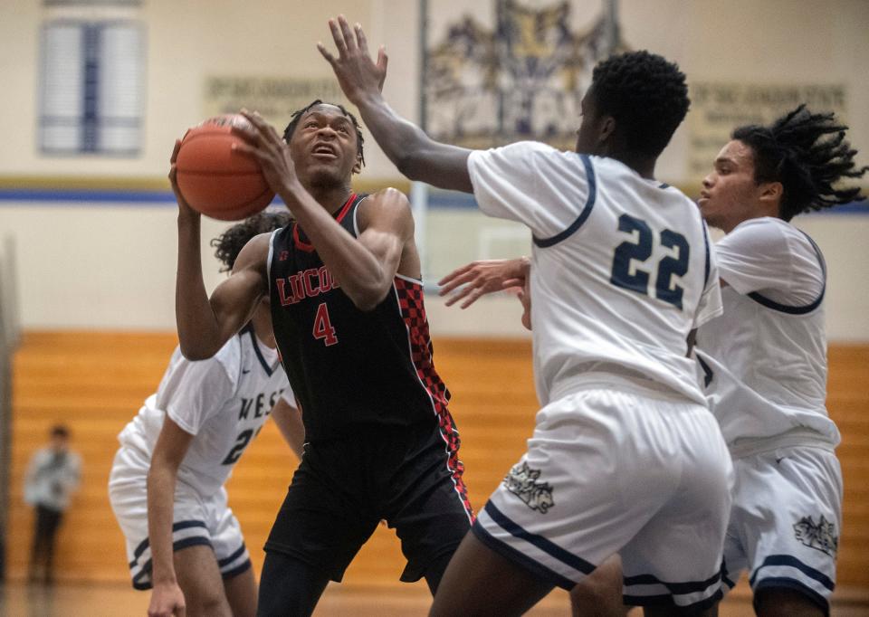 Lincoln's Anthony Moore, center, goes to the hoop against West's Yuvarj Mann, left, Isaac Tomtania and Joseph Walker during a boys varsity basketball game at West High in Tracy on Friday, Jan. 27, 2023. Lincoln won 59-27. 