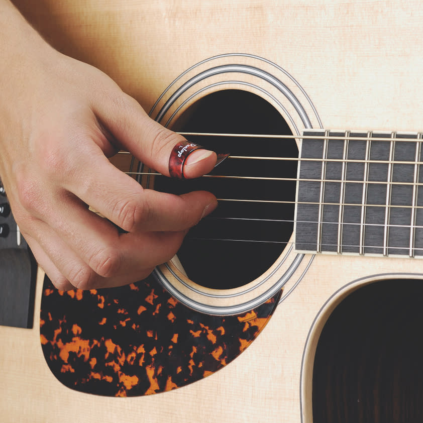 Someone thumbpicking an acoustic guitar