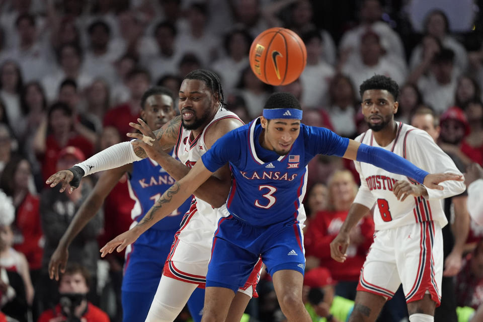 Kansas's Dajuan Harris Jr. (3) and Houston's J'Wan Roberts chase a loose ball during the first half of an NCAA college basketball game Saturday, March 9, 2024, in Houston. (AP Photo/David J. Phillip)