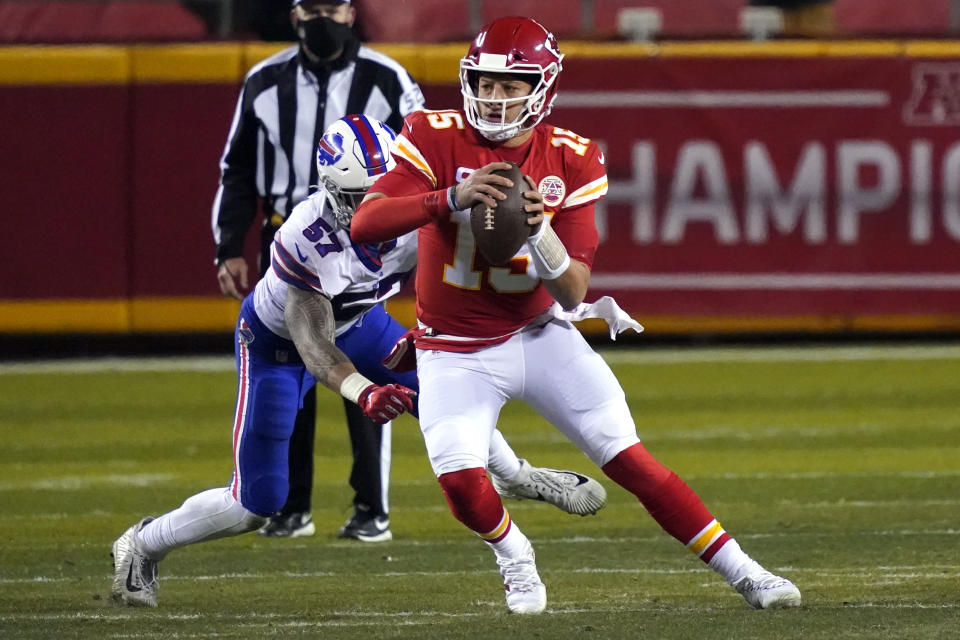 Kansas City Chiefs quarterback Patrick Mahomes (15) scrambles up field ahead of Buffalo Bills defensive end AJ Epenesa (57) during the first half of the AFC championship NFL football game, Sunday, Jan. 24, 2021, in Kansas City, Mo. (AP Photo/Jeff Roberson)