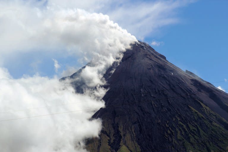 Mount Mayon spews a thick column of ash into the air on May 7, 2013, as seen from Albay province in the Philippines. Four foreign tourists and their Filipino tour guide were crushed to death when one of the Philippines' most active volcanoes spewed a giant ash cloud and a hail of rocks on Tuesday, authorities said