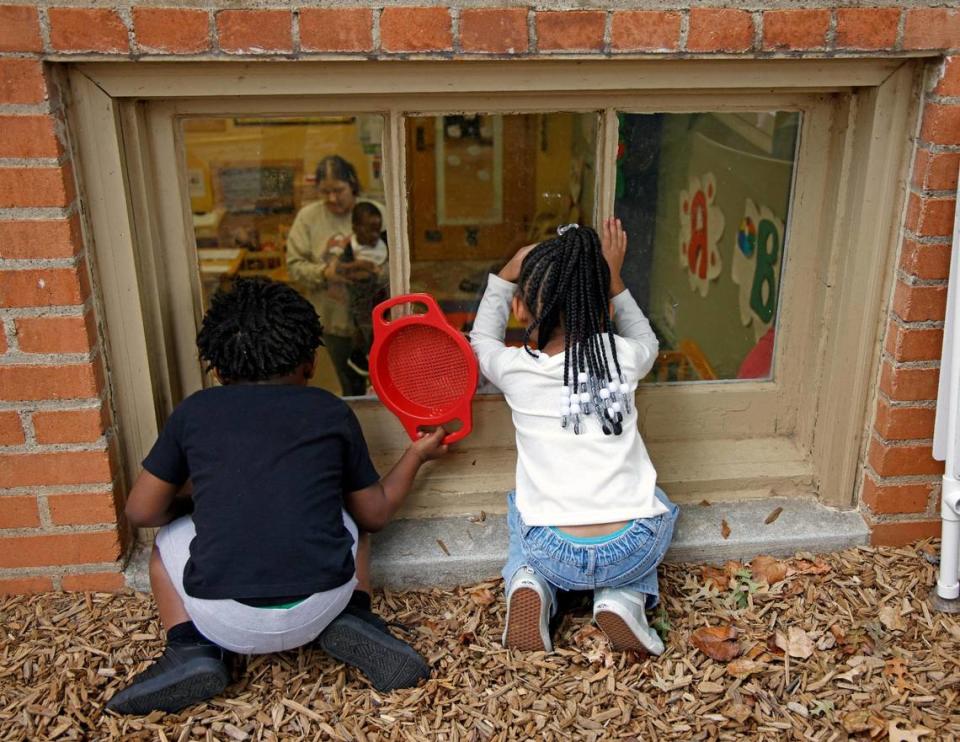 Children peek into a classroom during play time at the Rosie K. Mauk Child Development Center in Fort Worth on Wednesday.