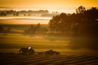 <p>A farm tractor and baler sit in a hay field on a misty morning near Cremona, Alberta, Tuesday, Aug. 30, 2016. (Jeff McIntosh/The Canadian Press via AP) </p>