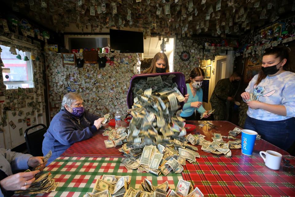 Kimberly Carson, center, dumps a bin full of bills removed from the walls onto the table for counting at Fat Smitty's in Discovery Bay on Wednesday.