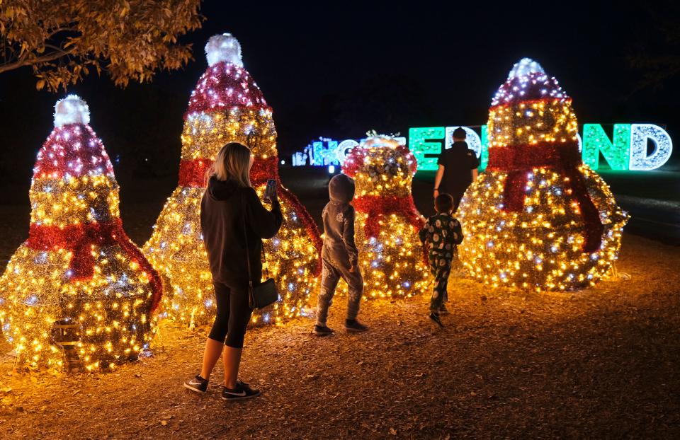 People walk through the Luminance holiday light display in Mitch Park in Edmond Thursday, December 2, 2021.