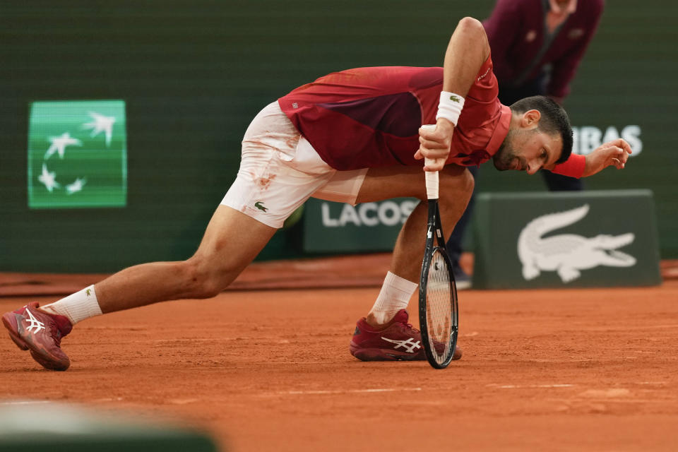 FILE - Serbia's Novak Djokovic slipped during his fourth round match of the French Open tennis tournament against Argentina's Francisco Cerundolo at the Roland Garros stadium in Paris, Monday, June 3, 2024. Novak Djokovic withdrew from the French Open with an injured right knee on Tuesday, June 4, 2024, ending his title defense and meaning he will relinquish the No. 1 ranking. (AP Photo/Thibault Camus, File)