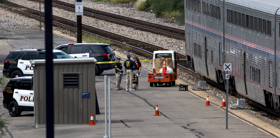 A Federal Bureau of Investigation evidence response team works at the scene of a shooting aboard Amtrak train in downtown Tucson, Ariz., on Monday, Oct. 4, 2021. (Rebecca Sasnett/Arizona Daily Star via AP)