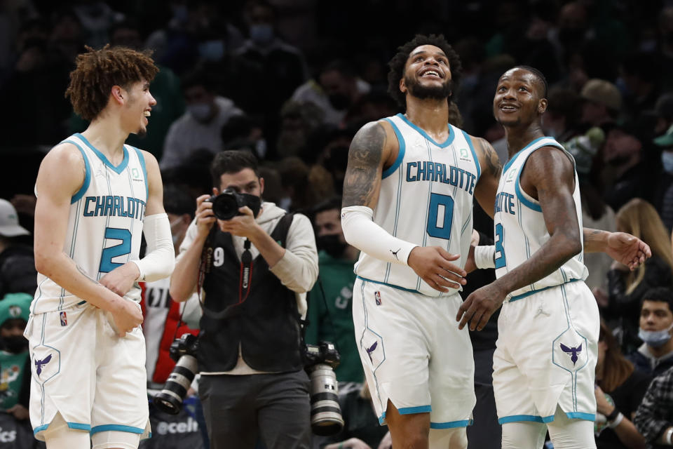 Charlotte Hornets' LaMelo Ball, left, Miles Bridges (0) and Terry Rozier celebrate after they defeated the Boston Celtics in an NBA basketball game Wednesday, Jan. 19, 2022, in Boston. (AP Photo/Winslow Townson)