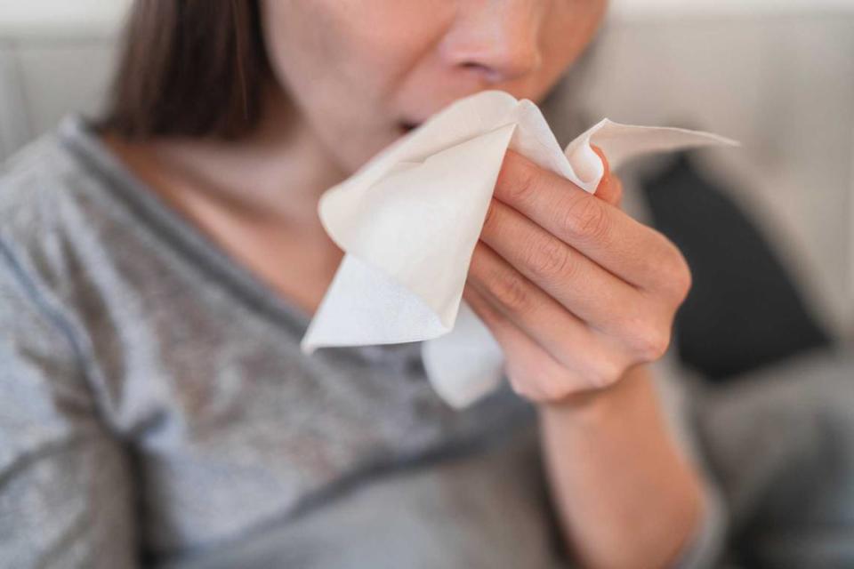 A woman sneezes into a tissue. Allergy levels are predicted to fluctuate in Sacramento this week with looming rain and wind in the forecast.