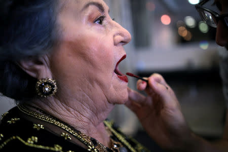 Holocaust survivor Polina Iluchin, 81, gets make up before the beginning of the annual Holocaust survivors' beauty pageant in Haifa, Israel October 14, 2018. REUTERS/Corinna Kern