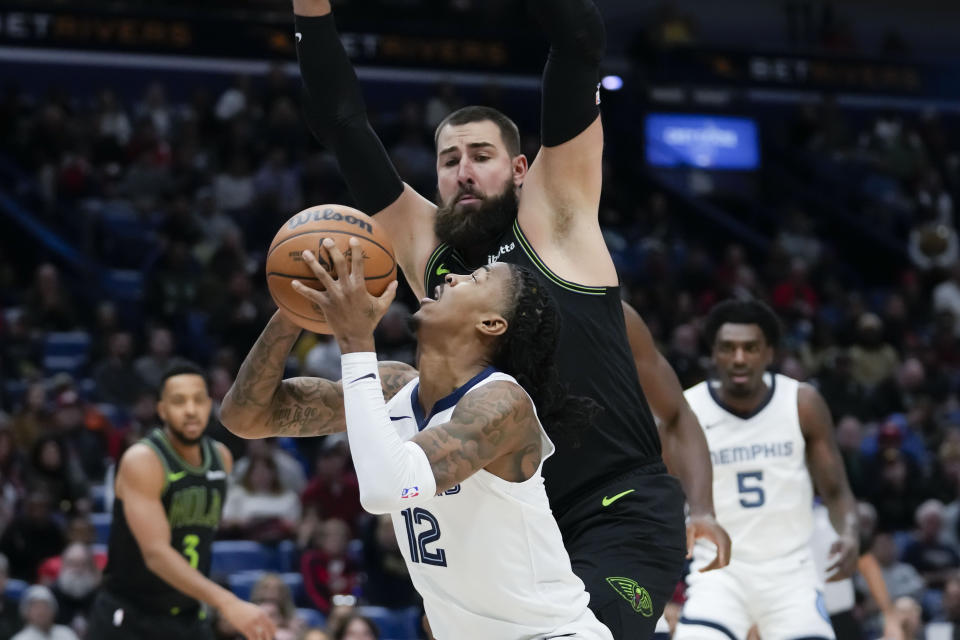 Memphis Grizzlies guard Ja Morant (12) looks to shoot against New Orleans Pelicans center Jonas Valanciunas in the first half of an NBA basketball game in New Orleans, Tuesday, Dec. 19, 2023. (AP Photo/Gerald Herbert)