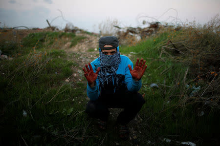 A Palestinian protester, nicknamed Abu Jaber, gestures with his hands stained with the blood of a wounded friend as he poses for a photograph at the scene of clashes with Israeli troops near the border with Israel, east of Gaza City, January 19, 2018. "We protest against the crazy decision made by Trump on Jerusalem and against the hardship we have experienced for more than 10 years due to the Israeli blockade. I hope the blood which you can see on my hands will move the Arab and Muslim world to revolt against Israel and America," said Abu Jaber. REUTERS/Mohammed Salem