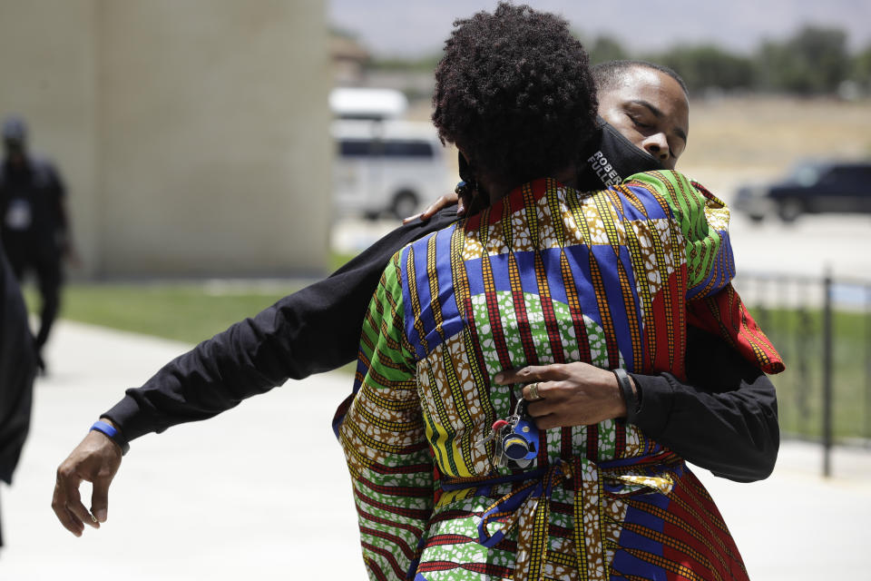 Mourners embrace during a funeral for Robert Fuller Tuesday, June 30, 2020, in Littlerock, Calif. Fuller, a 24-year-old Black man was found hanging from a tree in a park in a Southern California high desert city. Authorities initially said the death of Fuller appeared to be a suicide but protests led to further investigation, which continues. (AP Photo/Marcio Jose Sanchez)