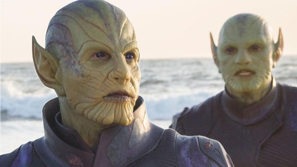 Two Skrull aliens, with ridged skin and pointy ears, stare stoically.