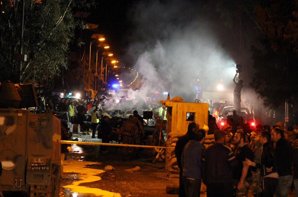 Lebanese army and citizens gather at the site of an explosion, in the predominately Shiite town of Hermel, about 10 miles (16 kilometers) from the Syrian border in northeast Lebanon, Saturday, Feb. 22, 2014. A suicide attacker blew himself up at an army checkpoint after troops tried to search his car Saturday, killing and wounding a number of people including soldiers in the latest blast linked to Syria's civil war, a senior military official and the state news agency said. (AP Photo)